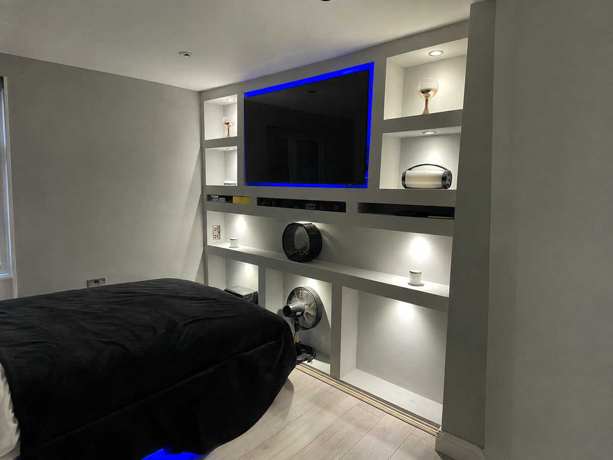 Finished media wall with recessed lighting, decorated to completion